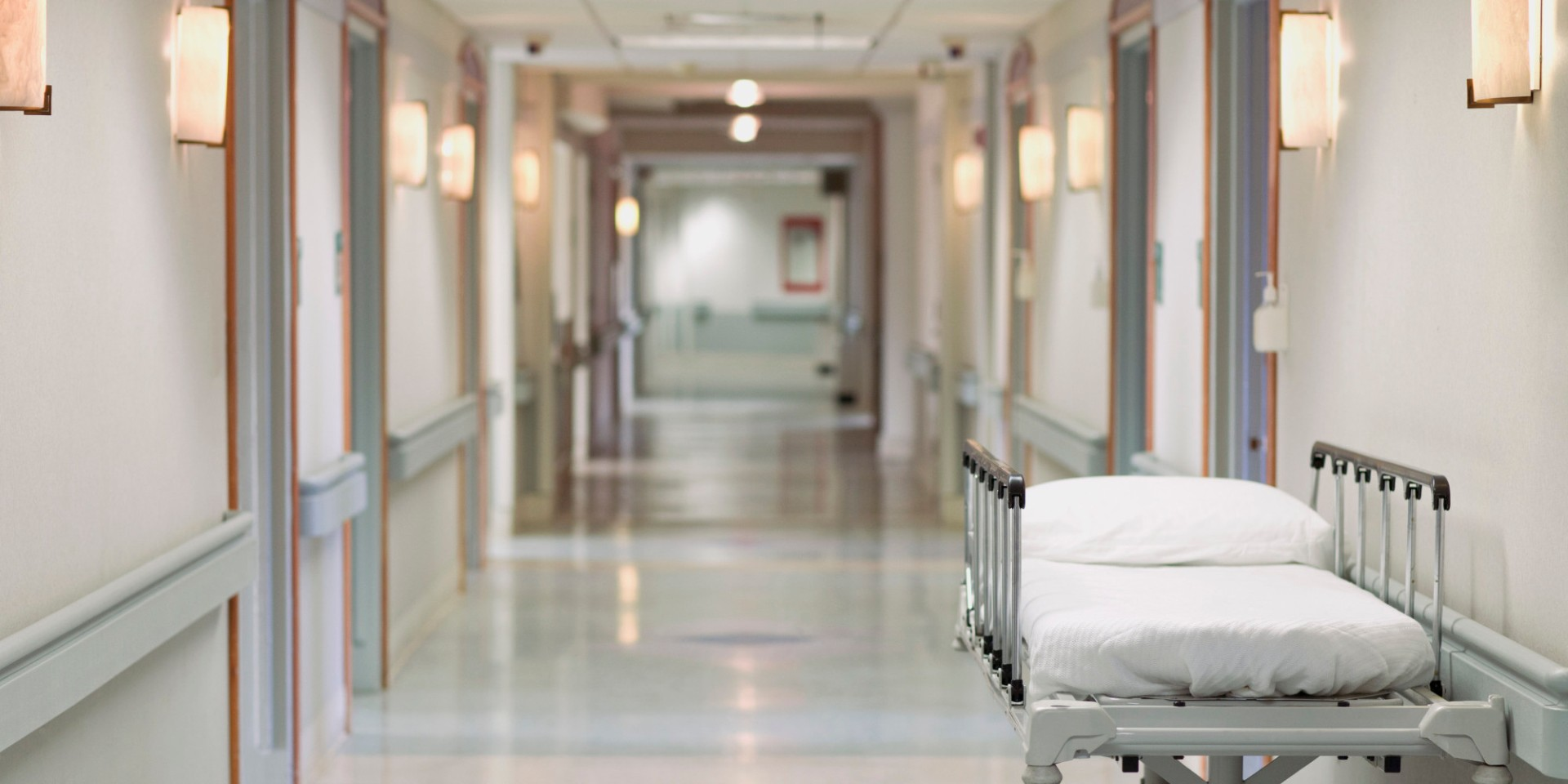 Bright hospital corridor with a patient bed, representing healthcare institutions served by VHC Holdings