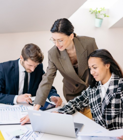 VHC Holdings team collaborating over reports and a laptop